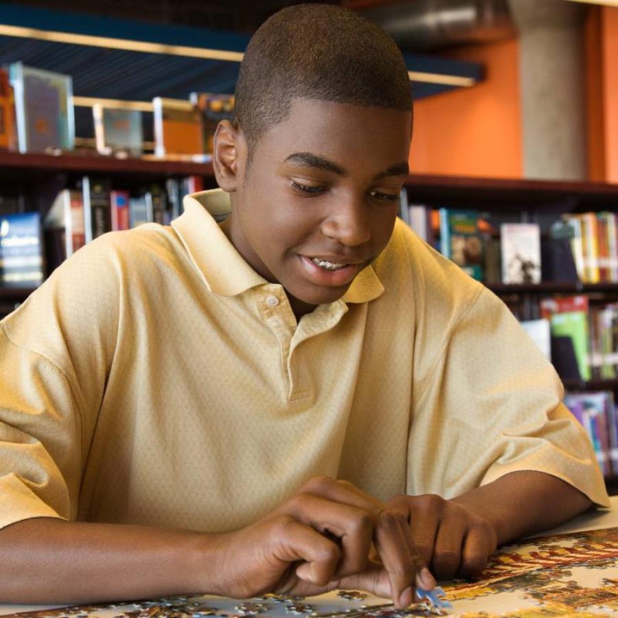 a young man assembling a jigsaw puzzle